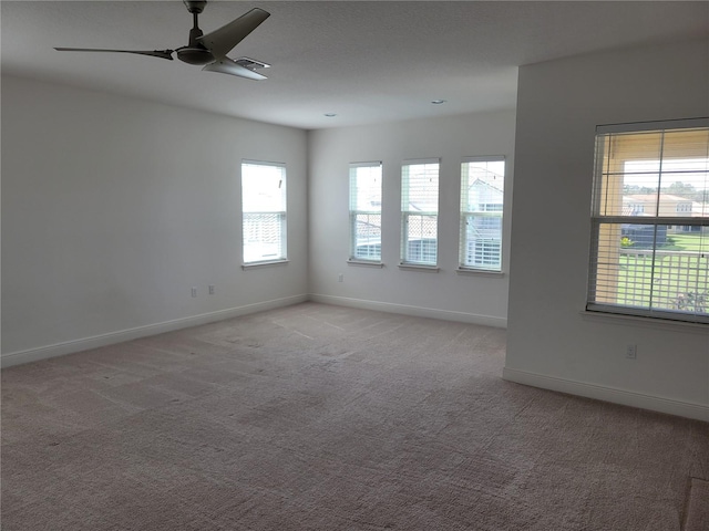 carpeted empty room with a wealth of natural light and ceiling fan