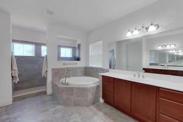 bathroom featuring vanity and tiled tub