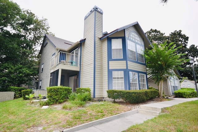 view of property exterior with a lawn and a balcony