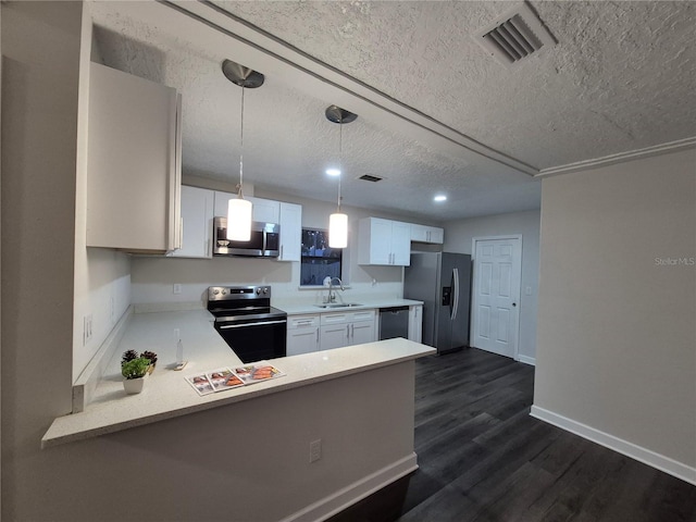 kitchen featuring kitchen peninsula, appliances with stainless steel finishes, sink, decorative light fixtures, and white cabinetry