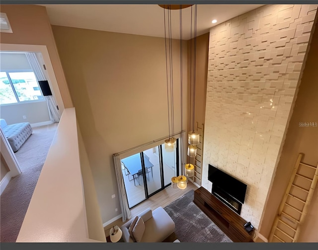 unfurnished living room featuring a fireplace, carpet floors, and a high ceiling