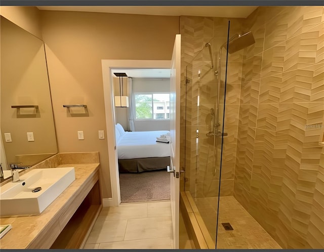 bathroom with tile patterned floors, vanity, and a tile shower