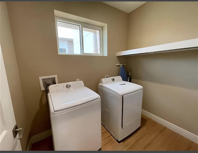 laundry room with light hardwood / wood-style flooring and washing machine and clothes dryer