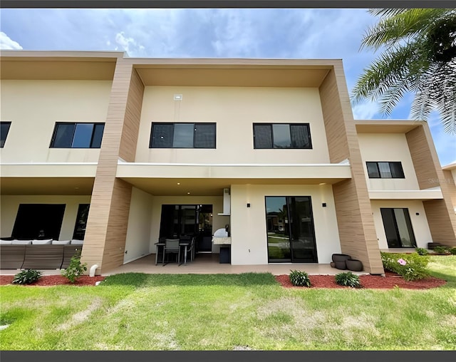 rear view of property with an outdoor living space, a yard, and a patio area