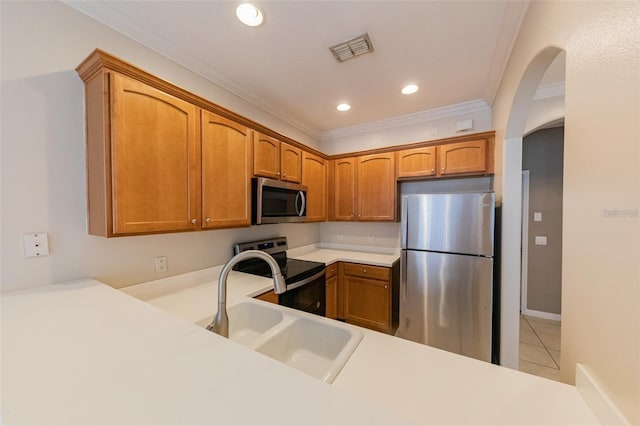 kitchen featuring crown molding, stainless steel appliances, light tile patterned floors, sink, and kitchen peninsula