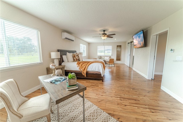 4121 Albritton Rd, Saint Cloud, FL 34772 - bedroom with a wall unit AC, light wood-type flooring, a textured ceiling, baseboards, and a ceiling fan