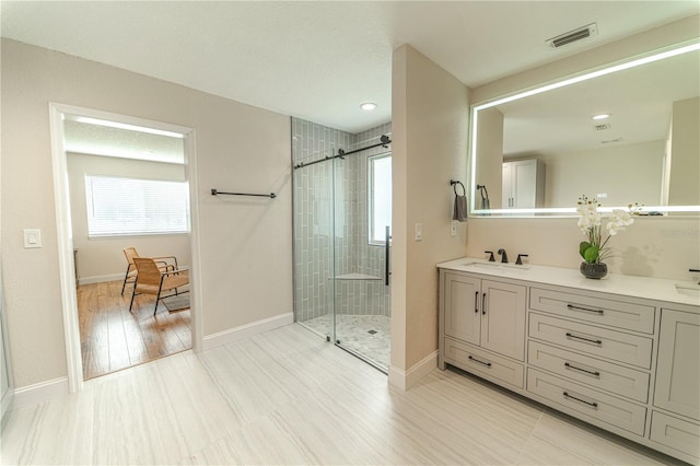 bathroom with hardwood / wood-style flooring, vanity, and walk in shower