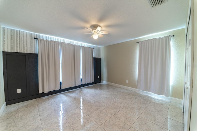 spare room featuring ceiling fan and a textured ceiling