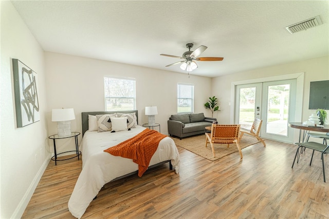 bedroom featuring hardwood / wood-style flooring, access to outside, and multiple windows