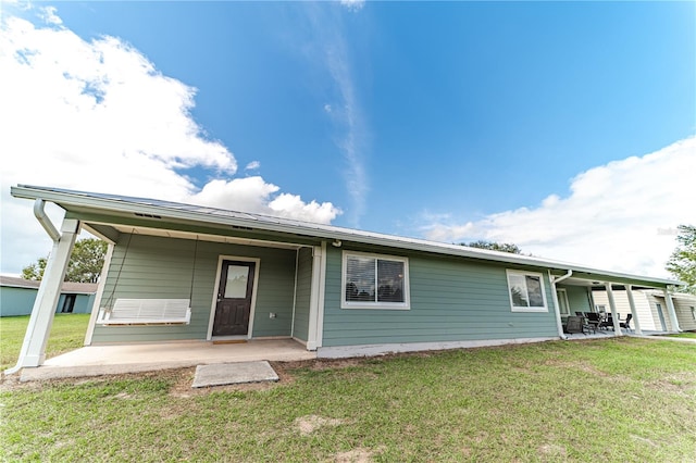 back of property with a yard and a patio