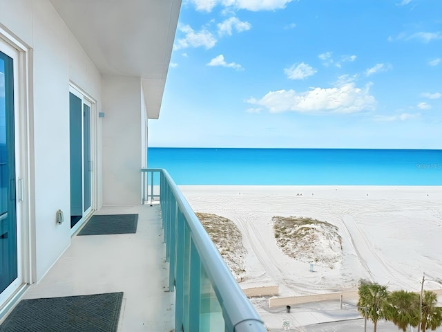 balcony featuring a water view and a beach view