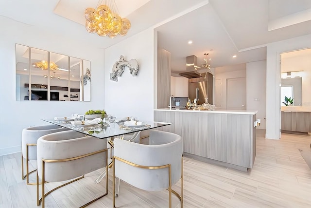 dining room featuring a chandelier, breakfast area, sink, and light hardwood / wood-style flooring