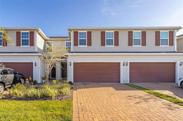 4919 Conifer Cone Dr, Kissimmee, FL 34746 - view of front facade featuring an attached garage, decorative driveway, and stucco siding
