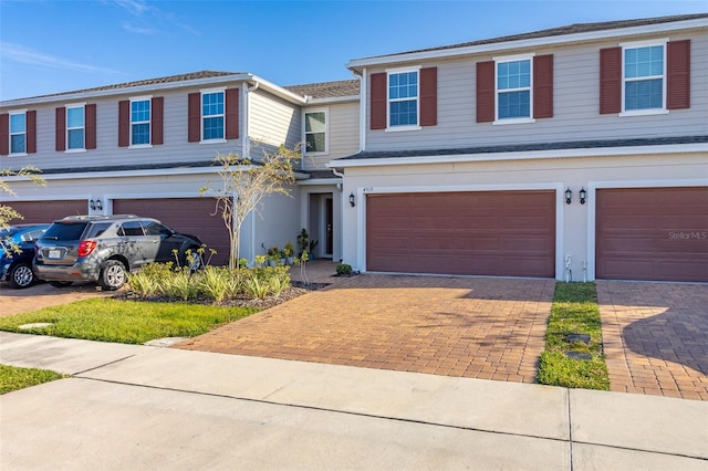4919 Conifer Cone Dr, Kissimmee, FL 34746 - view of front of home featuring an attached garage, decorative driveway, and stucco siding