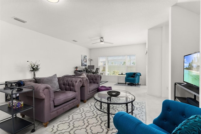 living room with ceiling fan and a textured ceiling