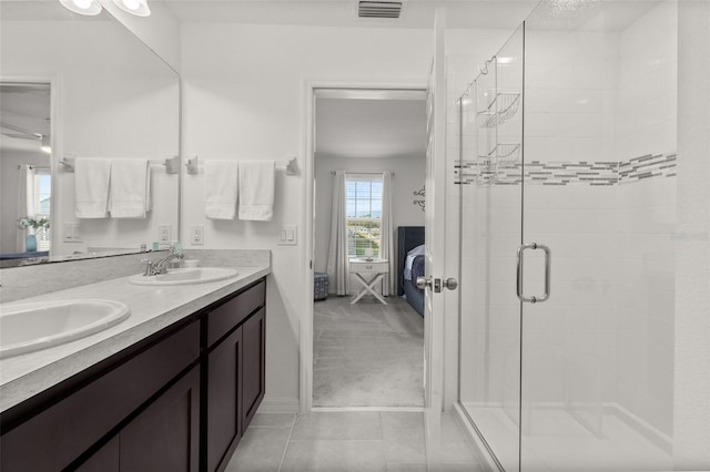 bathroom with walk in shower, vanity, and tile patterned floors