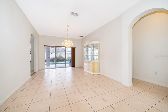 empty room with a chandelier and light tile patterned floors