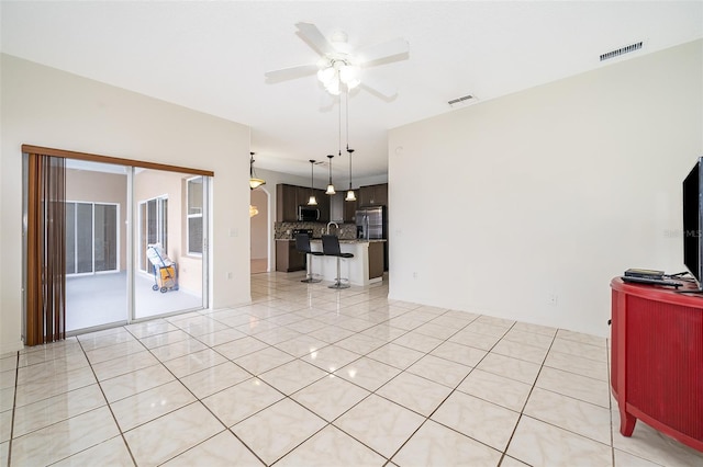 unfurnished living room featuring ceiling fan and light tile patterned floors