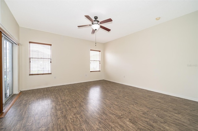 empty room with plenty of natural light, dark hardwood / wood-style floors, and ceiling fan