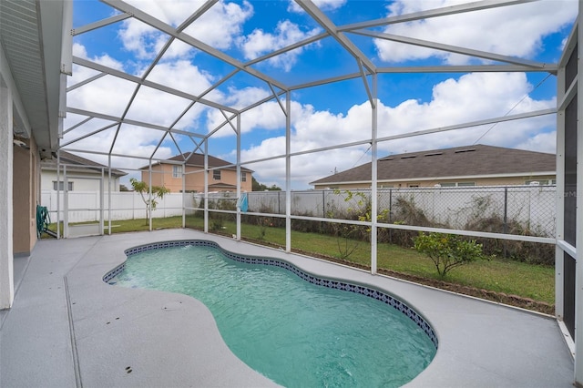 view of pool with glass enclosure, a lawn, and a patio