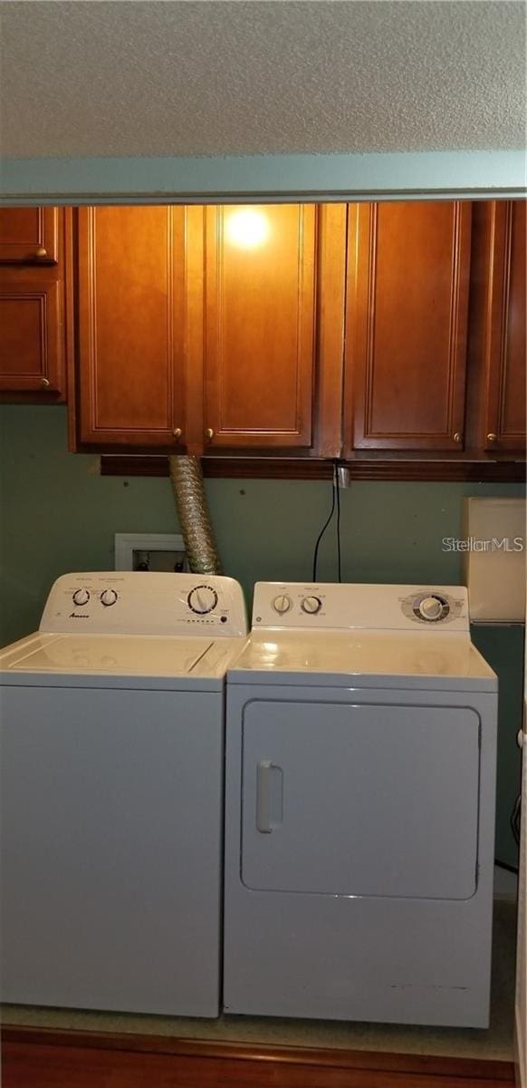 washroom with washer and dryer and cabinets