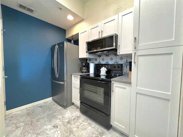 kitchen featuring stainless steel appliances, white cabinetry, and tasteful backsplash