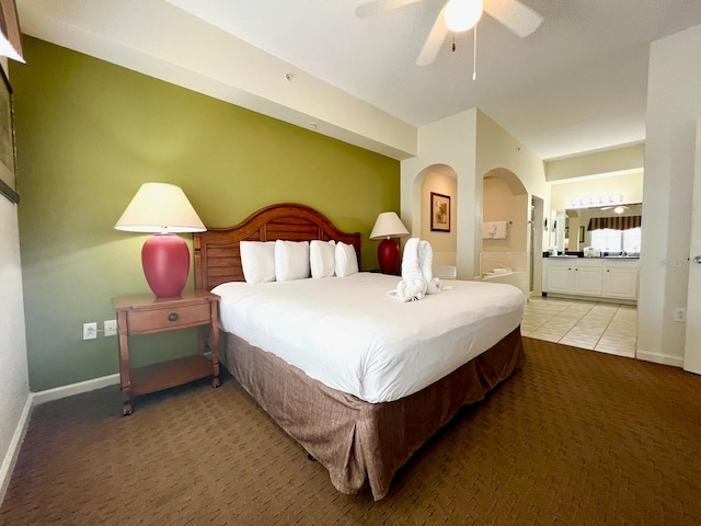 bedroom with ensuite bath, ceiling fan, and light carpet