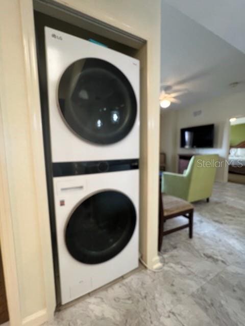 clothes washing area featuring ceiling fan and stacked washer / drying machine