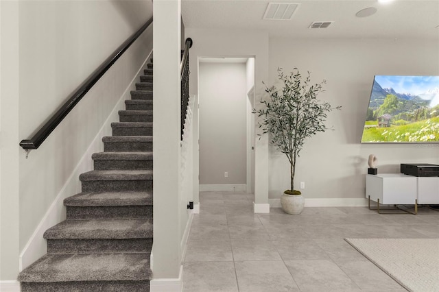 stairs featuring tile patterned flooring and a barn door