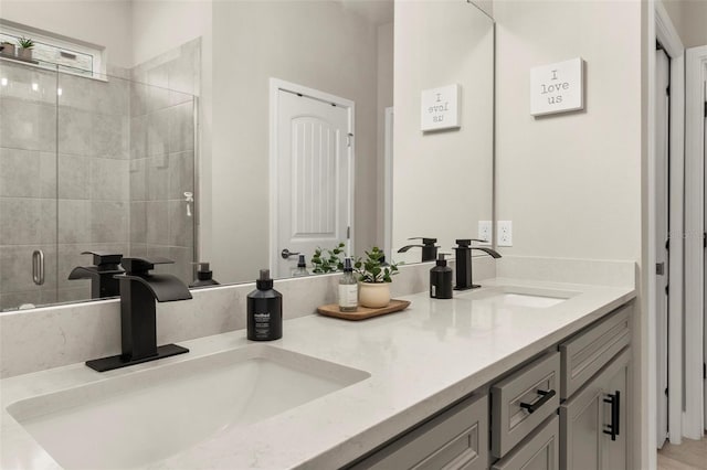 bathroom featuring a shower with door and vanity