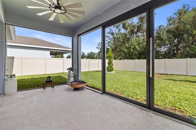 unfurnished sunroom featuring ceiling fan