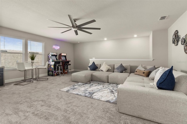 carpeted living room featuring ceiling fan and a textured ceiling