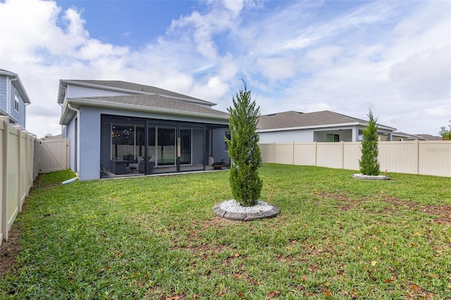 rear view of property with a yard and a sunroom