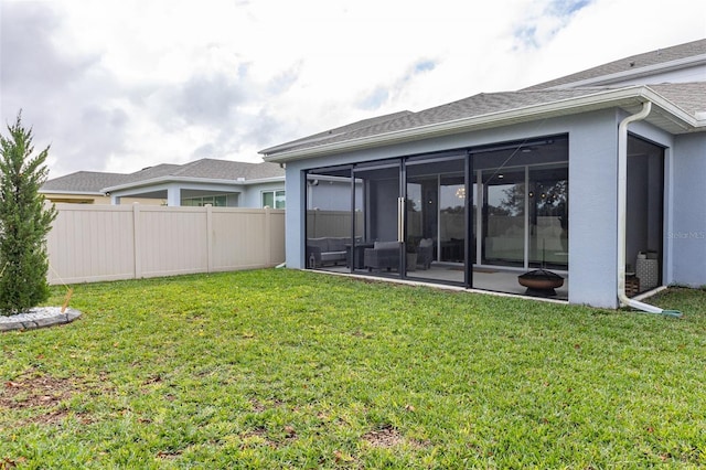 back of house featuring a lawn and a sunroom