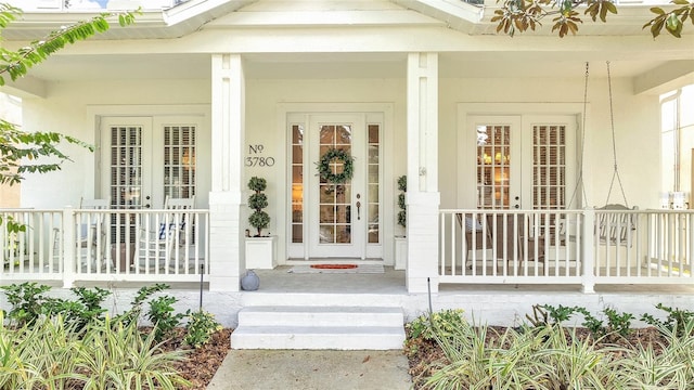 entrance to property featuring covered porch and french doors