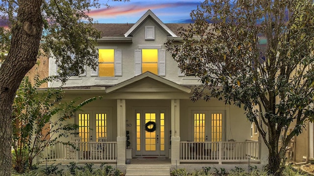 view of front of home with a porch and french doors