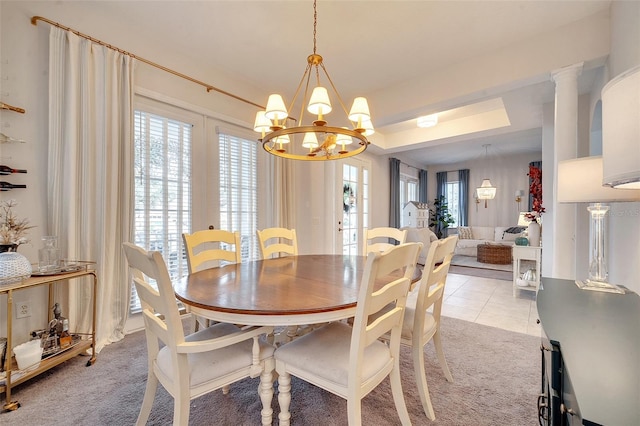 tiled dining room featuring an inviting chandelier, french doors, and decorative columns