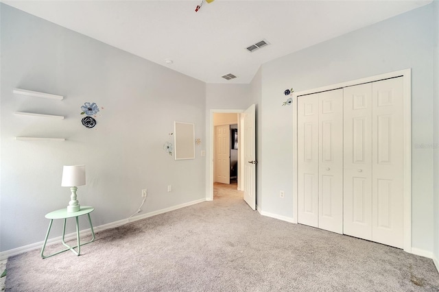 unfurnished bedroom featuring a closet and light colored carpet