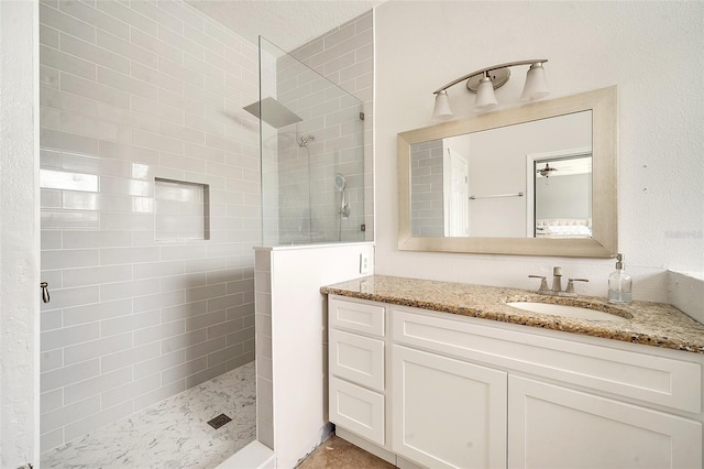 bathroom with vanity and a tile shower