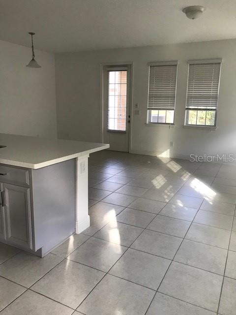 interior space with pendant lighting and light tile patterned floors