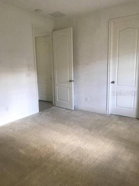 spare room featuring light carpet