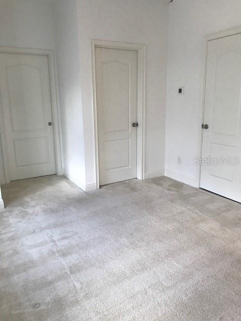 unfurnished room featuring light carpet