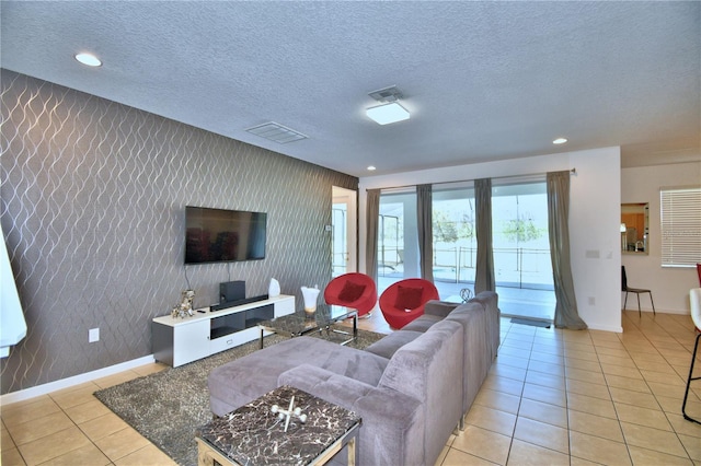 living room with a textured ceiling and light tile patterned flooring