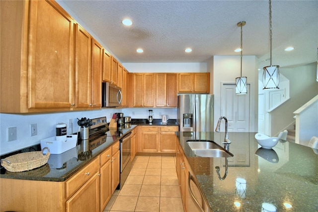 kitchen with stainless steel appliances, sink, light tile patterned floors, decorative light fixtures, and dark stone countertops