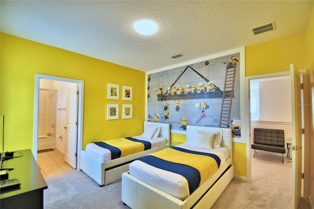 bedroom featuring ensuite bathroom, light colored carpet, and a textured ceiling