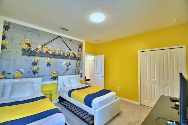 bedroom featuring carpet flooring, a textured ceiling, and a closet