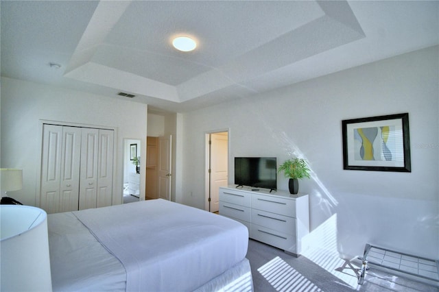 bedroom with a closet and a tray ceiling