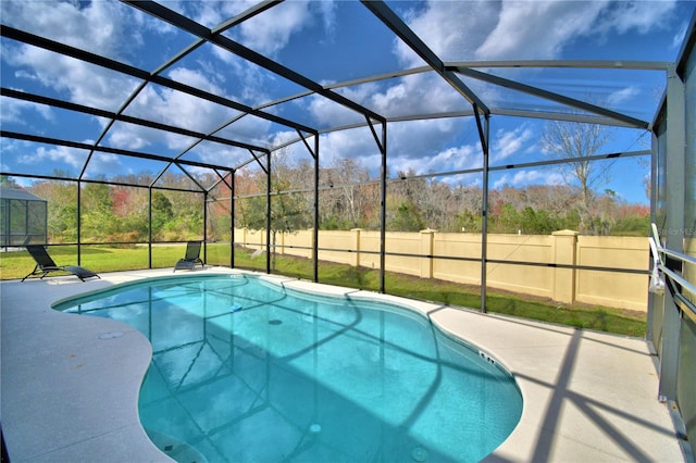 view of pool featuring glass enclosure, a lawn, and a patio area