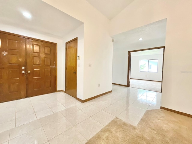 entryway featuring lofted ceiling and light carpet