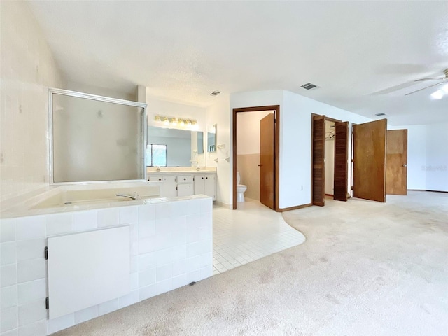 bathroom with tile patterned floors, vanity, toilet, a shower, and ceiling fan